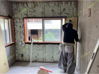 PBを壁に貼り付ける様子